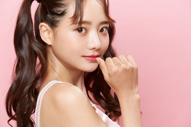 親指を口にあてる女性