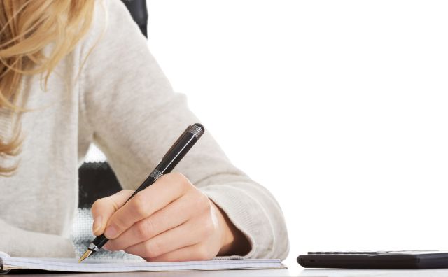 机でメモする女性